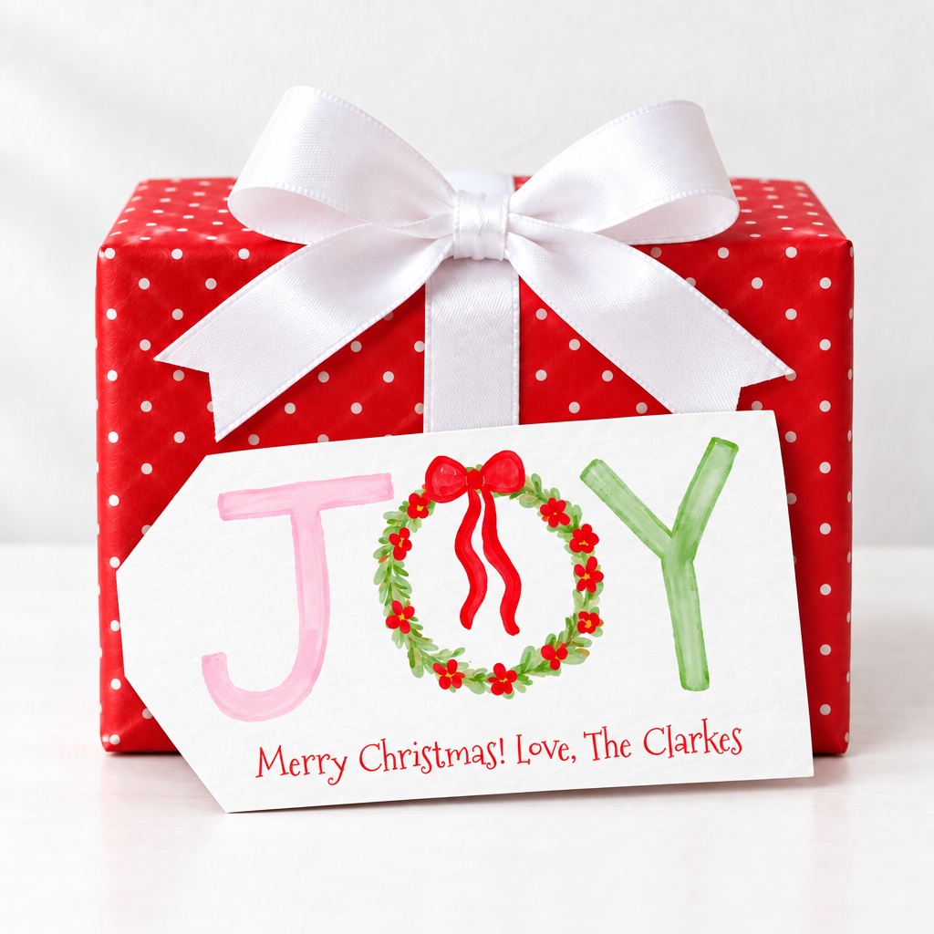 Large angled JOY tag without a hole, propped against the red polka-dot present